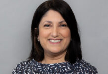 A dark-haired woman smiles at the camera