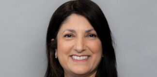 A dark-haired woman smiles at the camera