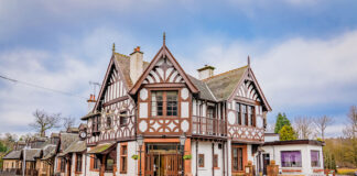 A Tudor-style Scottish hotel sits by a road