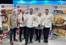 A man in chef's whites receives an award from his peers