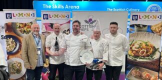 A man in chef's whites receives an award from his peers