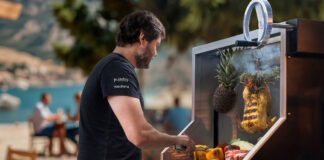 A man cooks meat and vegetables on an outdoor grill