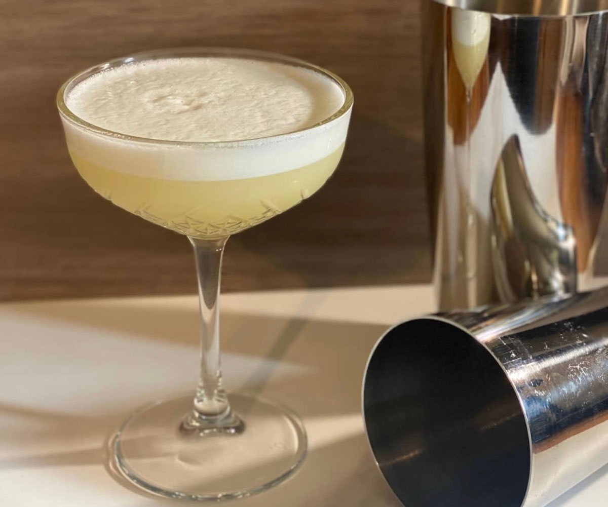 A foamy yellow drink in a cocktail glass