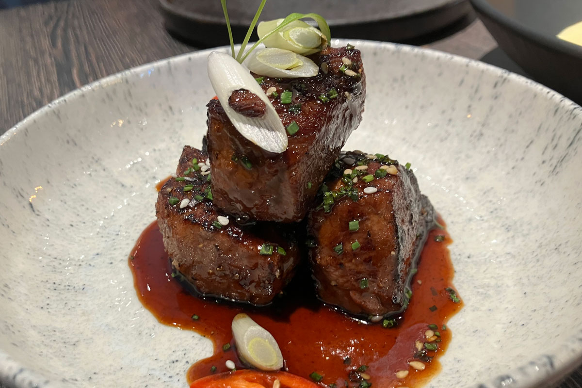 a plate of spicy, sticky cooked meat