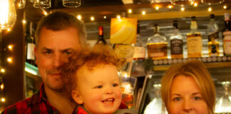 A mother, father and baby son in a warmly lit bar