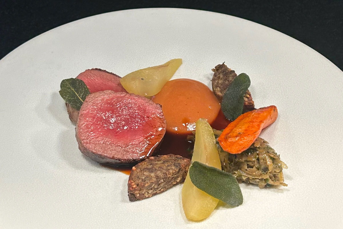 a plate of food featuring rare red meat and root vegetables