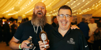Two men look very pleased to be sampling whisky