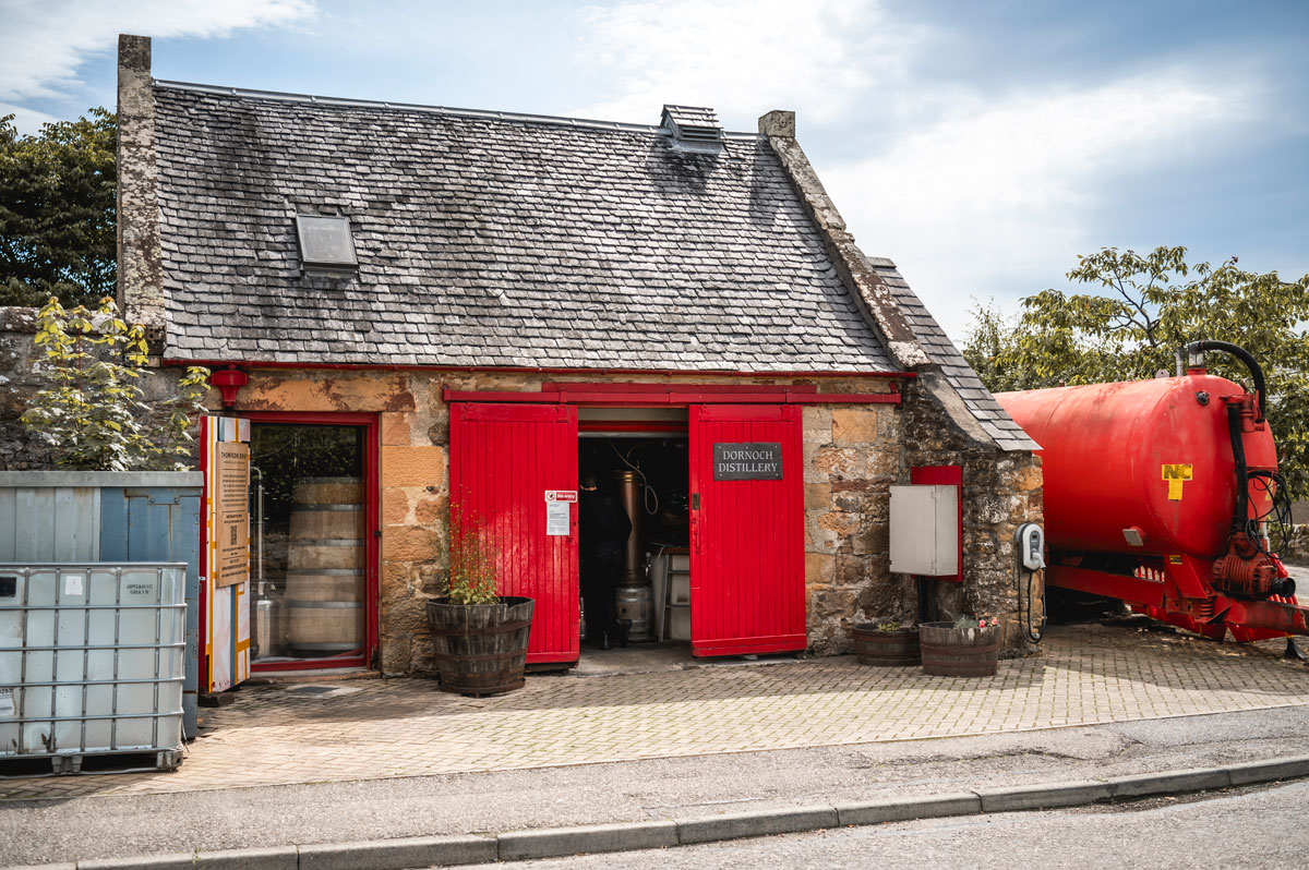 A small traditional distillery with red doors