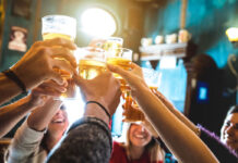 Pub customers say 'cheers' by raising their glasses of beer and cider