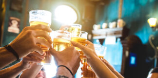 Pub customers say 'cheers' by raising their glasses of beer and cider