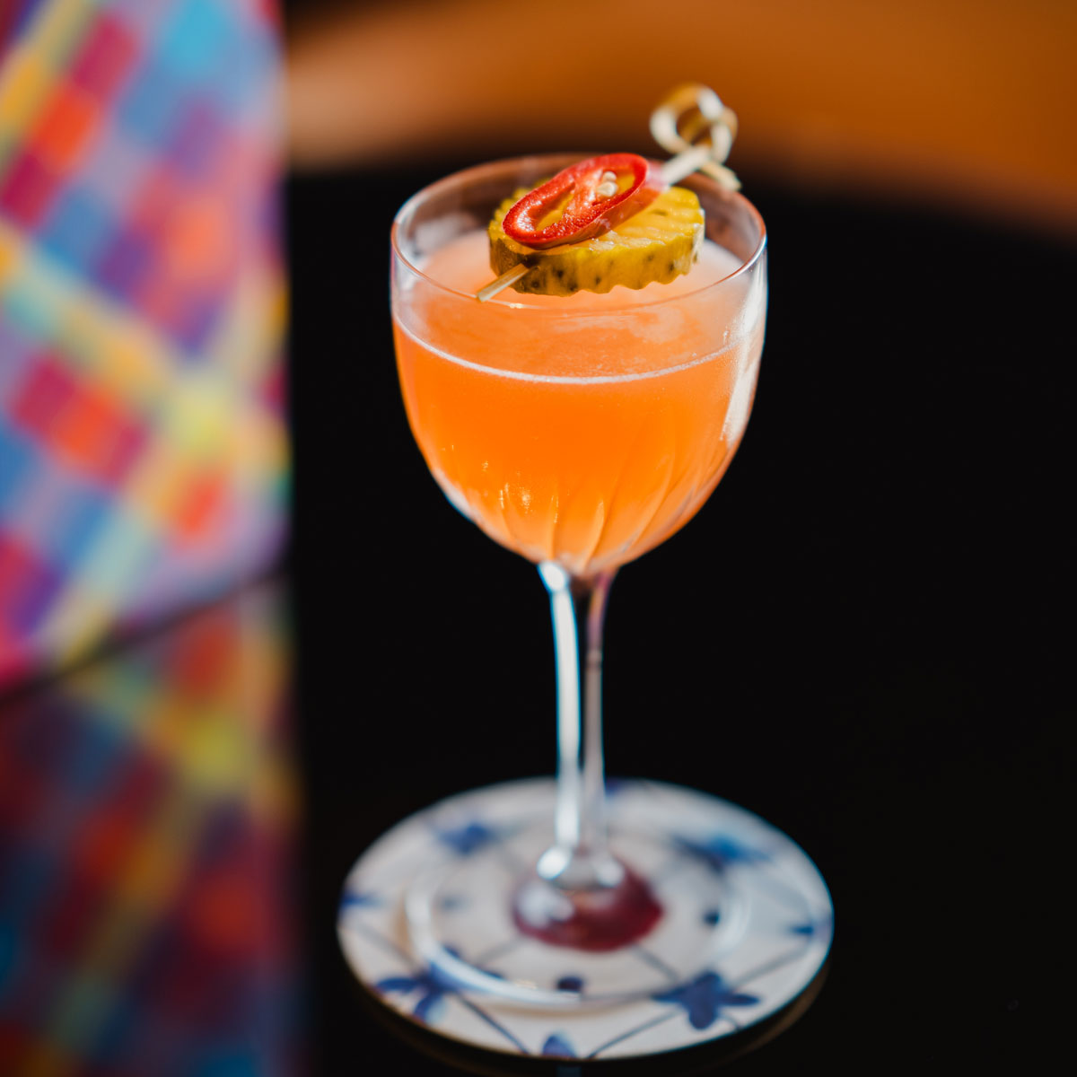 A red cocktail with a chilli slice