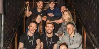 A team of cheerful hospitality trade professionals sitting on a staircase