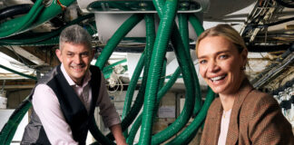 A man and a woman in a pub cellar with the green pipes of a modern beer dispense
