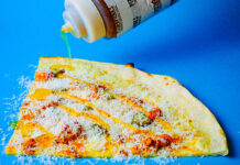 a big slice of pizza getting hot honey drizzled onto it