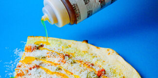 a big slice of pizza getting hot honey drizzled onto it