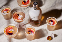 Fruity looking cocktails surround a bottle of tequila