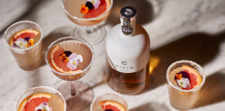 Fruity looking cocktails surround a bottle of tequila