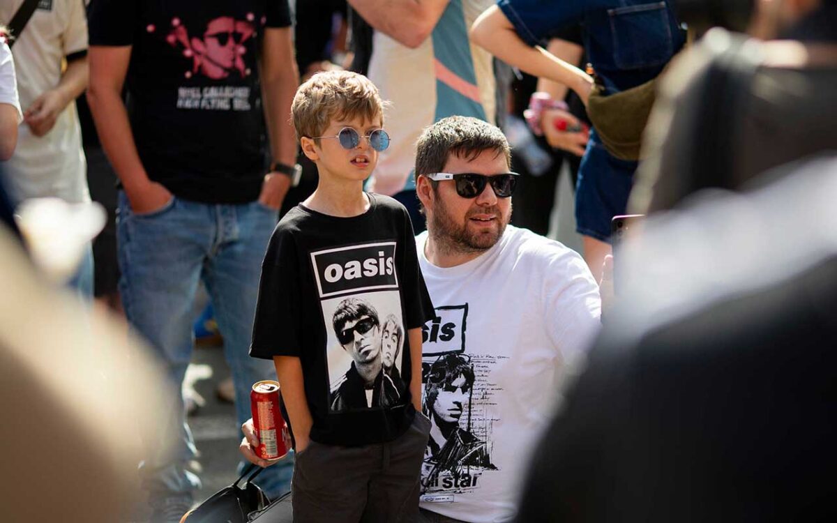 A father and son attending an Oasis concert.