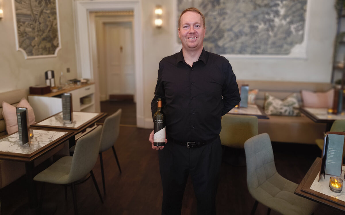 The assistant manager of Cuvee in Glasgow with a bottle of wine. 