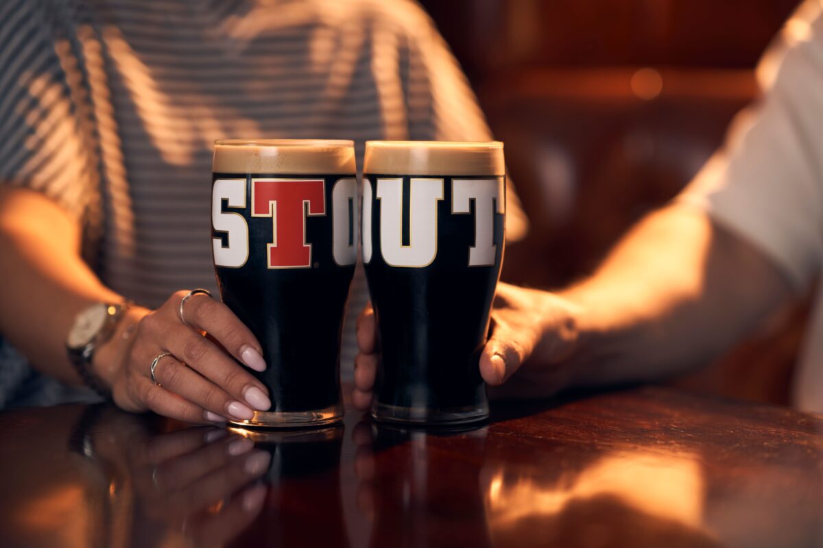 Two pints of Tennent's Stout on a bar.